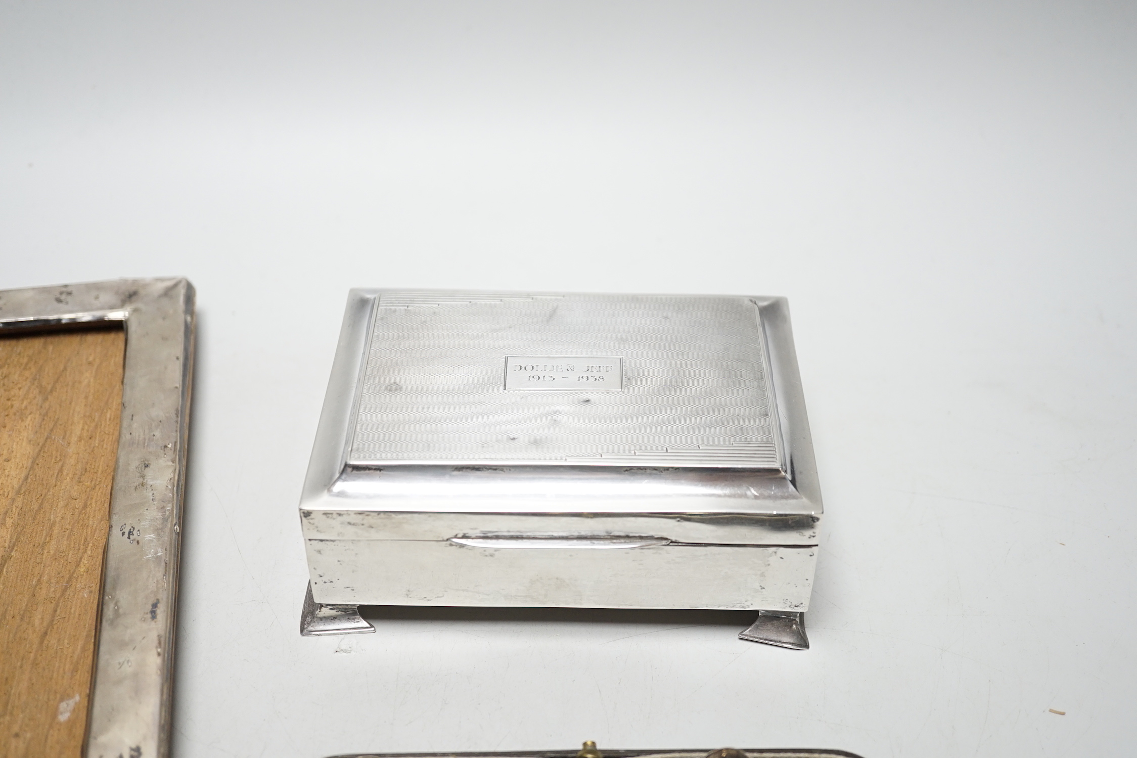 A set of six George VI silver teaspoons, Birmingham, 1939, cased, a silver cigarette box and a silver framed photograph frame.